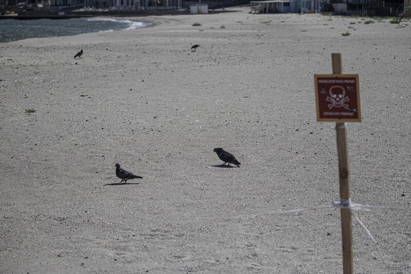 An innocuous-looking beach near Odesa, Ukraine, bears a sign warning of the deadly presence of mines and banning sea swimming. Although the summer season has started in the city, known as the 'Pearl of the Black Sea', it is forbidden to enter the water, which is also closed to ship traffic. Photograph: Metin Aktas/Anadolu Agency/Getty