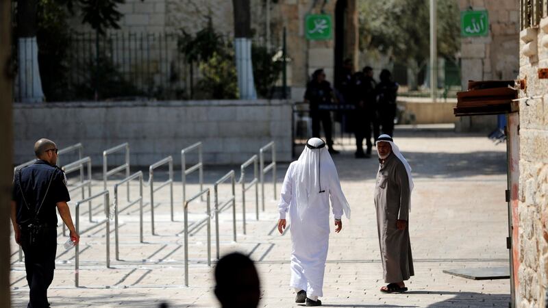 Palestinians walk next to the entrance of the compound known to Muslims as Noble Sanctuary and to Jews as Temple Mount  after Israel removed new security measures there. Photograph: Ronen Zvulun/Reuters