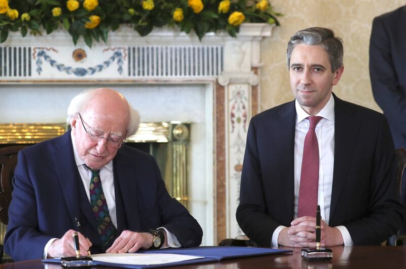 Harris and Higgins sign the paperwork at the Áras. Photograph: Colin Keegan/Collins Dublin