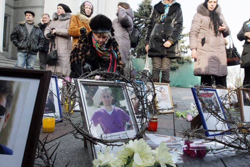 People place portraits of Maidan protesters killed in clashes with police at a makeshift memorial in front of the parliament in Kyiv on February 26th, 2014. Photograph: Anatolii Boiko/AFP via Getty 