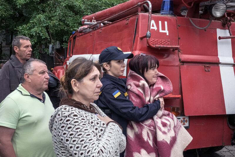 A police officer comforts a resident as onlookers watch the rescue efforts at the Ria Lounge. Photograph: Mauricio Lima/New York Times