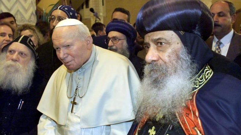 Religious observance: Pope John Paul II is escorted by Pope Shenouda III of Alexandria (right) in Cairo while Patsy McGarry (far left) looks on. Photograph: AP Photo/Jerome Delay