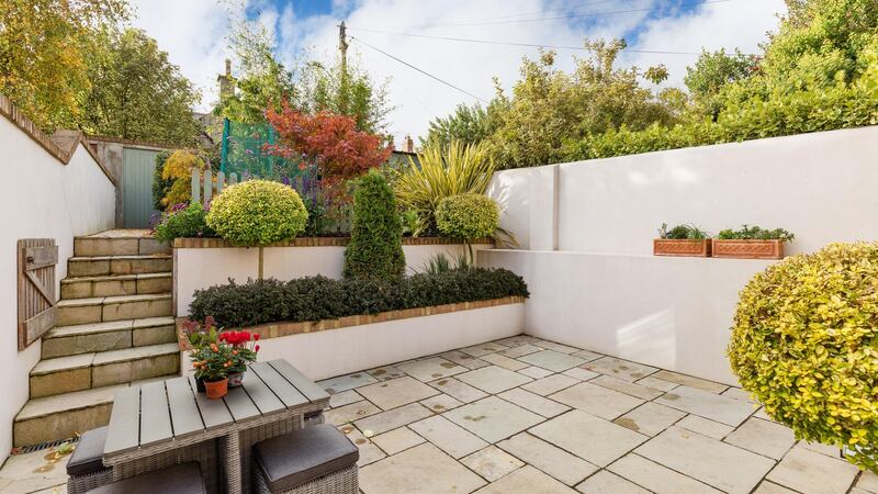The doors open out to a valuable south-facing flagstone patio and a garden landscaped by Garden Transformation that is stepped to the back, rising to meet the southern aspect sunlight.