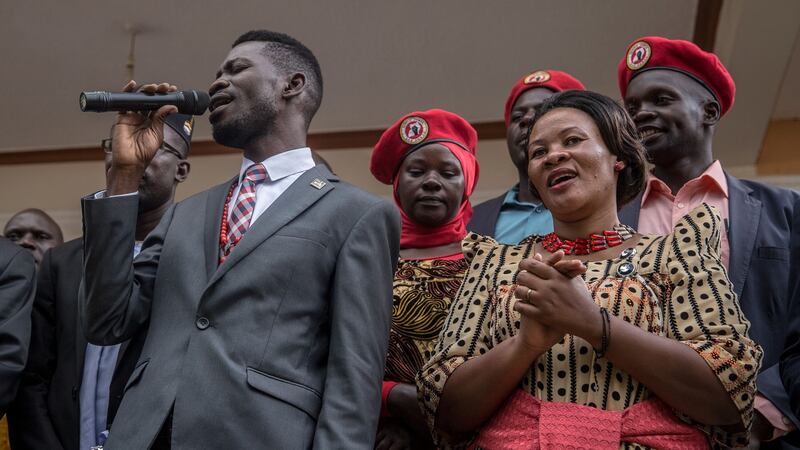 Bobi Wine speaks at a campaign event, surrounded by supporters wearing his trademark red beret. Photograph: Sally Hayden.