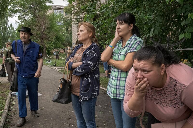 Onlookers watch rescue efforts at the site of the Russian missile strike on the Ria Lounge  in Kramatorsk, Ukraine. Photograph: Mauricio Lima/New York Times
                      