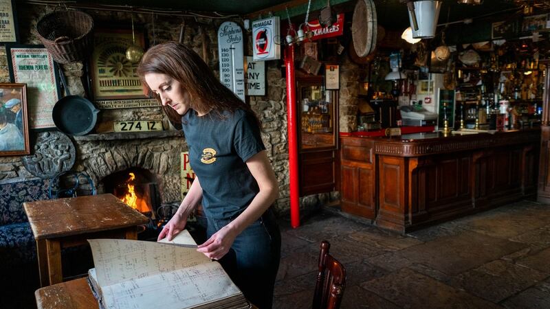Marie Mellett of Mellett’s pub in Swinford, Co Mayo, with a ledger showing transaction’s from the early 20th century including the time of the Spanish Flu epidemic. Photograph: Keith Heneghan