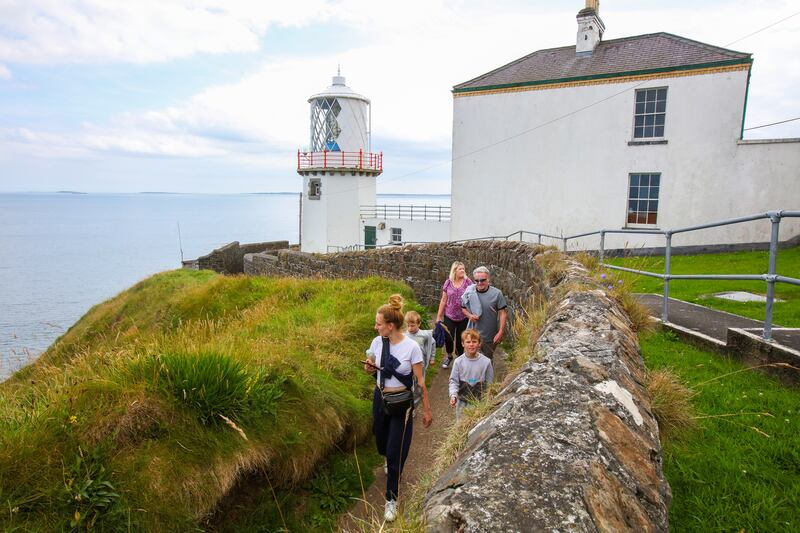 People walk the cliff path beside Blackhead Lighthouse on the east coast of Co Antrim. Photograph: Paul Faith