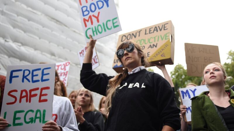Demonstrators hold up signs outside the Irish Embassy in London,  supporting calls  for more liberal Irish abortion laws. Photograph: Mary Turner/Reuters