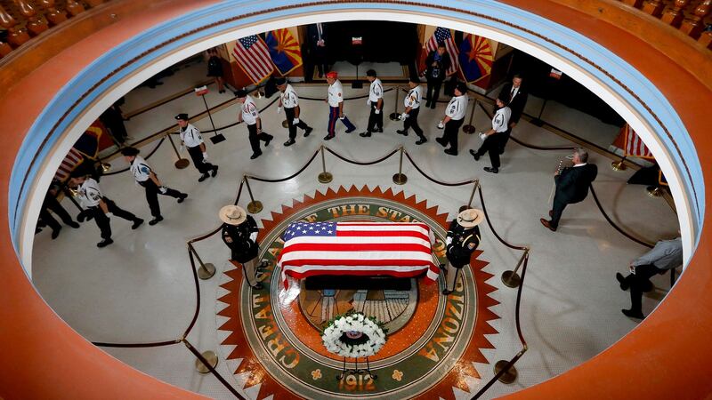 Veterans walk past the late US senator John McCain’s coffin at a service in Phoenix, Arizona. Photograph: Ross D Franklin/AFP