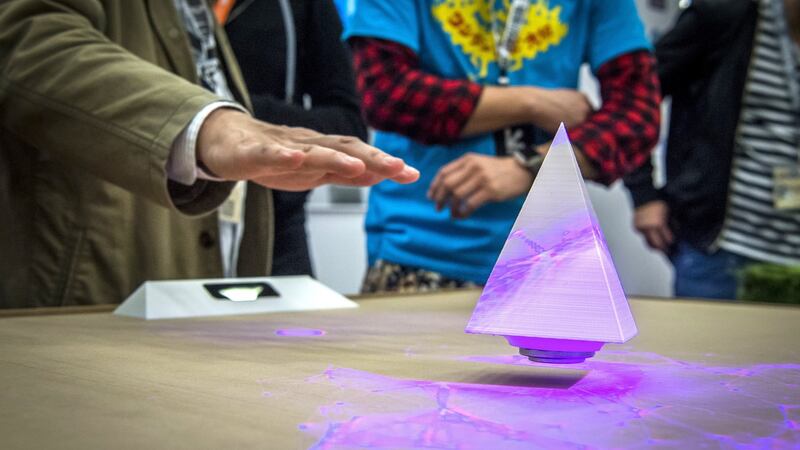 An attendee demonstrates a levitation device using a projector manufactured by Ray Corp at the SXSW conference. Photographer: David Paul Morris/Bloomberg