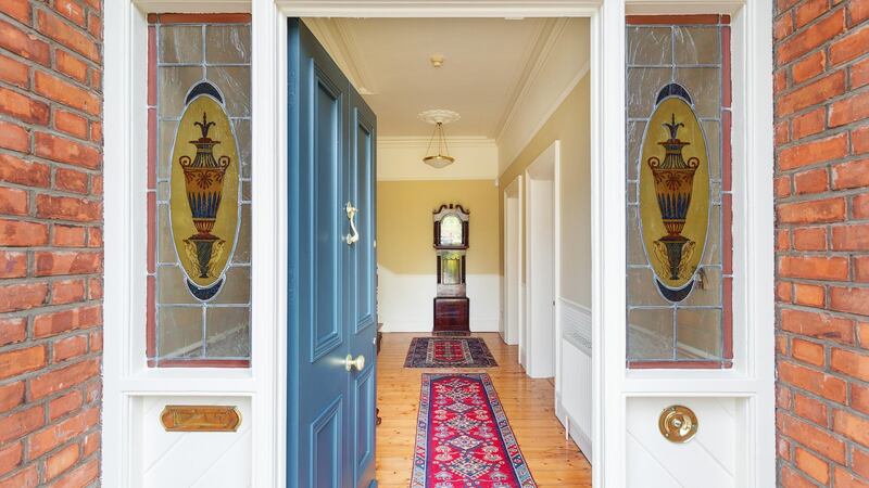 The front door has particularly lovely coloured glasswork,  and the hallway is wide, with  dado and picture rails