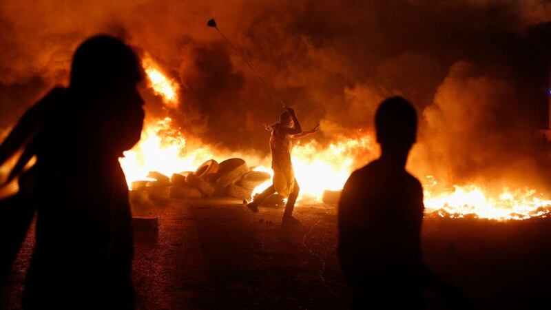 A Palestinian protester uses a slingshot to hurl stones toward Israeli troops during clashes, at a protest against Israeli offensive in Gaza. Photograph: Mohamad Torokman /Reuters