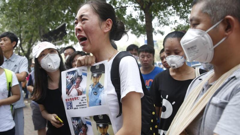 A family member  of a missing firefighter from the recent explosions at a chemical warehouse protests outside a hotel where authorities are holding a press conference in Tianjin. Photograph: Getty/AFP