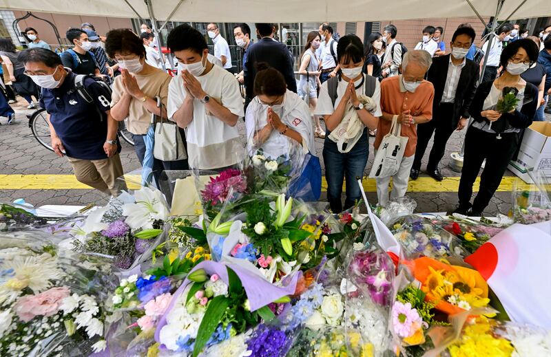 People offer prayers at a makeshift memorial near the scene where Shinzo Abe was fatally shot. Photograph: Kyodo News/AP