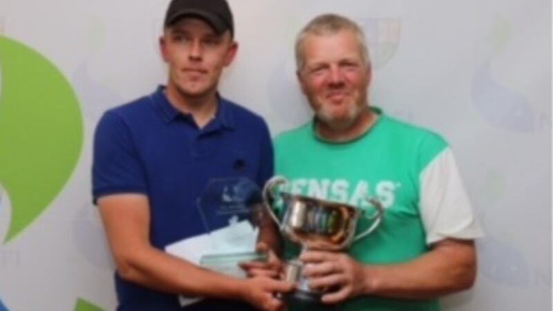 2016 champ Vaidas Jagela (left) is presented with the trophy by Julian Kendrick, secretary of the NCFFI