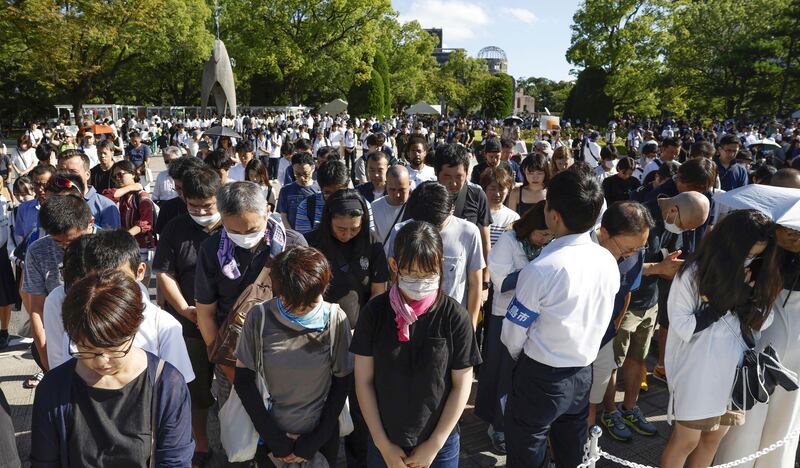 People at the ceremony observed a moment of silence with the sound of a peace bell. Photograph: AP