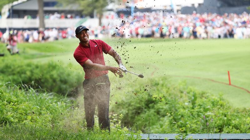 Woods plays out of the hazard on the 17th. Photo: Jamie Squire/Getty Images
