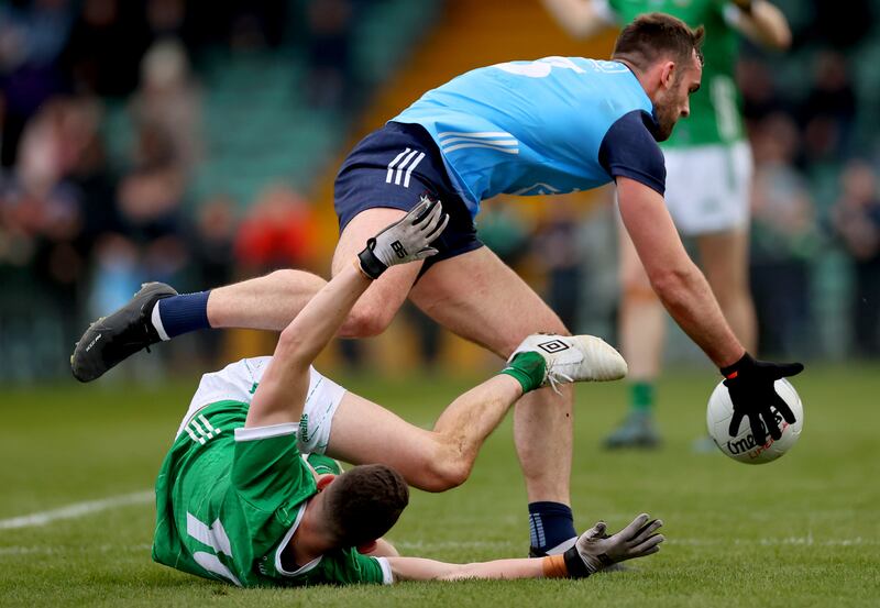 Limerick’s Paul Maher takes a tumble as Seán MacMahon retrieves the ball for Dublin. Photograph: James Crombie/Inpho