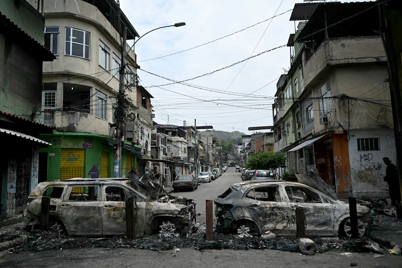 A man stands next to cars burnt during a barricade within the Operacao Contencao (Operation Containment) at the Vila Cruzeiro favela, in the Penha complex, in Rio de Janeiro, Brazil, on October 28, 2025. Photograph: Mauro Pimentel/Getty Images