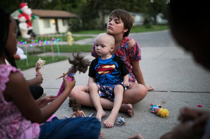 Bailey Allen holding Brody, her little brother, outside their home.