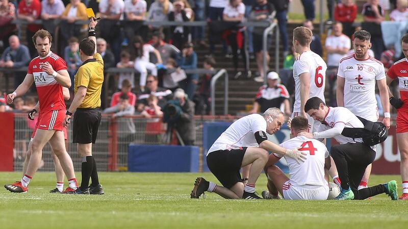 Derry’s Padraig Cassidy receives a yellow card for a high challenge on Michael McKernan of Tyrone. Photograph: Lorcan Doherty/Inpho