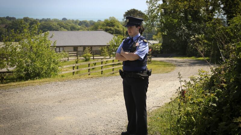 A garda stands outside the house  where four children were found badly injured in Blainroe, Co Wicklow. Photograph:   Garry O’Neill