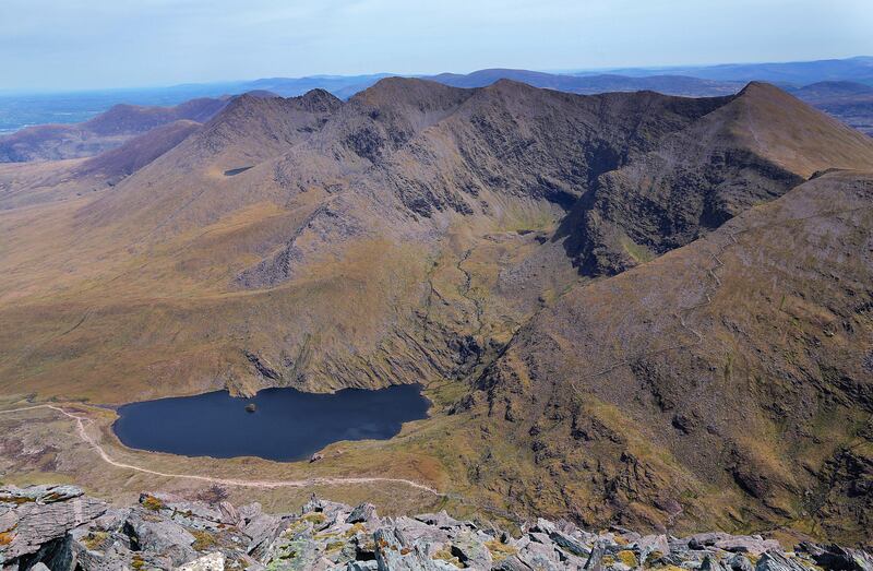 A view of the eastern reeks from the summit of Carrauntoohil, showing Cnoc an Bhreaca (hill of the Speckled Slabs); Cruach Mhór (big stack); An Ghunna Mhór (big gun); Cnoc na Péiste (hill of the serpent); Maolán Buí (golden knoll); Cnoc an Chuillinn (hill of the holly); Cnoc na Toinne (hill of the wave); and Lough Callee, served by tributaries of Lough Cummeenapeasta. Photograph: Valerie O'Sullivan