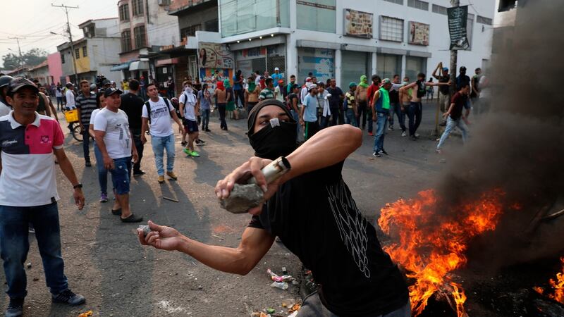 A demonstrator throws rocks during clashes with the Bolivarian National Guard in Urena, Venezuela, near the border with Colombia. Photograph: Rodrigo And/AP