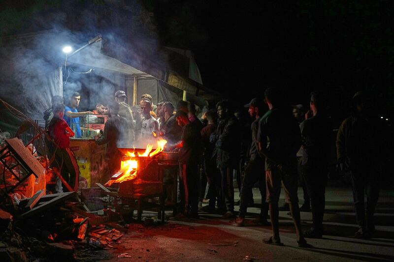 Palestinians line up to buy dinner at a food stand near the beachfront at a tent camp for displaced people in Gaza City. Photograph: Jehad Alshrafi/AP
