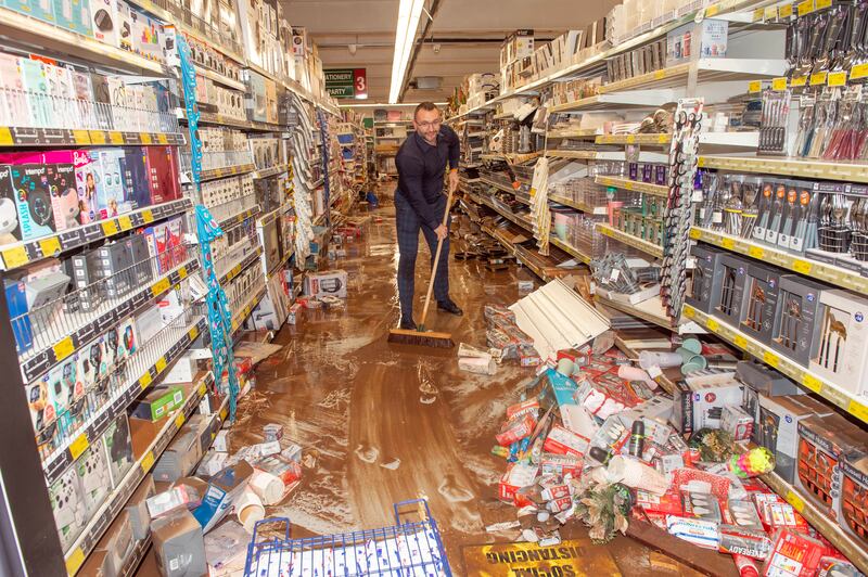 Darius Grskl mops out Home Store shop which was damaged by flooding in Midelton, Co Cork. Photograph: Michael Mac Sweeney/Provision