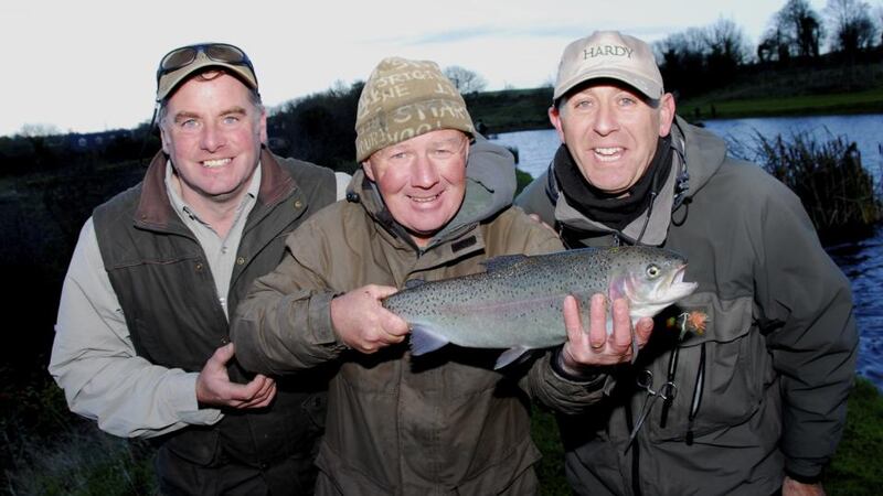 Michael Flanagan of the Sunday World shows off his rainbow trout with Courtlough staff Garrett Ruigrok and Stuart Marry