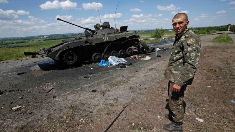 An Ukrainian soldier stands near a destroyed armoured vehicle at Slaviansk, in eastern Ukraine. Photograph: Maxim Zmeyev/Reuters