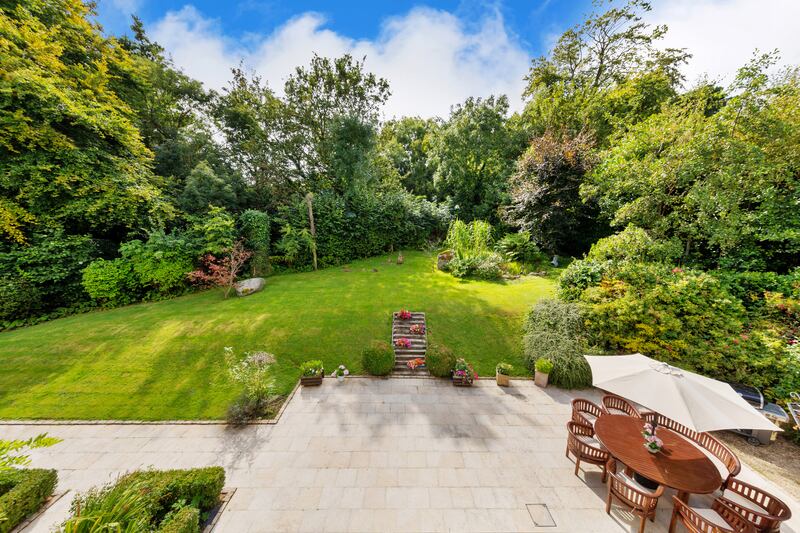 There are steps up to the lawn where there’s a small greenery-fringed pond (covered with a grate). 