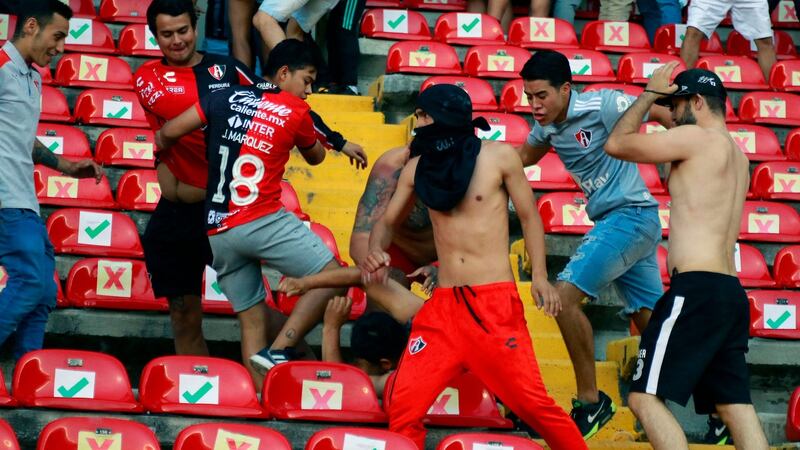 Querétaro and Atlas fans clash in the stands. Photograph: Eduardo Gomez/AFP via Getty Images