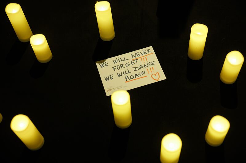 A message that reads 'We will never forget!!! We will dance again!!!' lies between candles at the Nova Music Festival exhibition in Berlin, Germany. Photograph: EPA