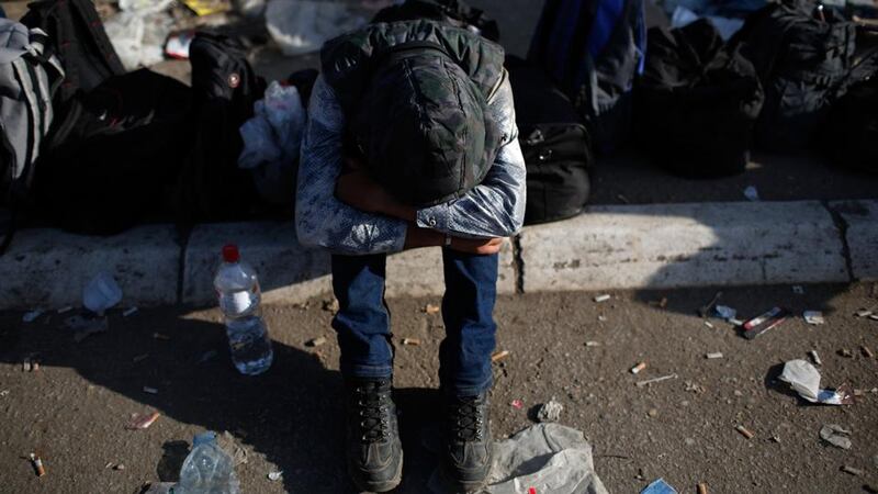 An exhausted Iraqi migrant tries to sleep as he keeps his place in a queue with thousands waiting for travel documents to be issued outside a Serbian processing facility on September 5th in Preshevo, Serbia. Photograph: Win McNamee/Getty Images