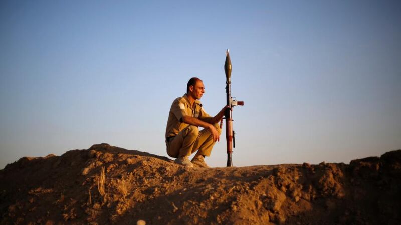 A Kurdish Peshmerga fighter keeps guard as his colleagues train before deploying to fight the Islamic State, at a temporary military camp near the front line in Gwar in  northern Iraq. Photograph: Ahmed Jadallah/Reuters.