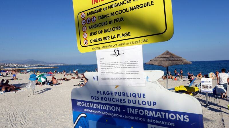 A bylaw forbidding women to wear burkini is posted on an information panel at a public beach in Villeneuve-Loubet, French Riviera, southern France. France’s top administrative court has overturned Villeneuve-Loubet’s burkini ban amid shock and anger worldwide after some Muslim women were ordered to remove body-concealing garments on French Riviera beaches. Photograph: AP