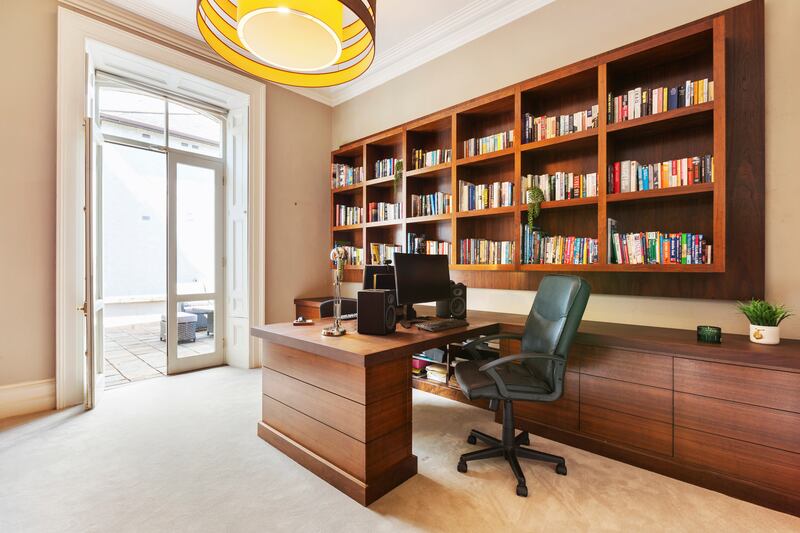 Office with solid wood bespoke fitted shelving and floor-to-ceiling built-in storage