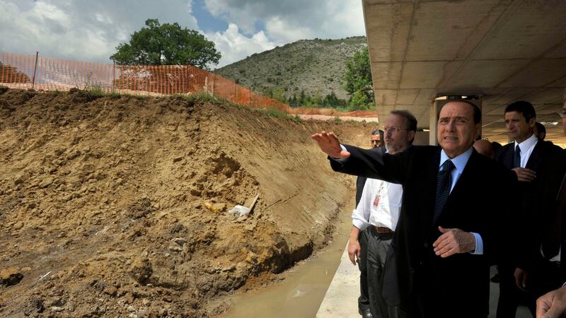 Italy’s then  prime minister Silvio Berlusconi surveys the progress of a construction site in Cese di Preturo, near the earthquake-hit town of L’Aquila, in July  2009. Photograph: Sandro Perozzi/AP