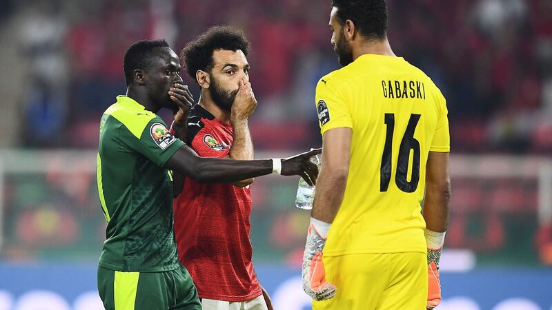 Salah gives advice to the Egyptian goalkeeper before Mané joins the conversation. Photo: Charly Triballeau/AFP via Getty Images