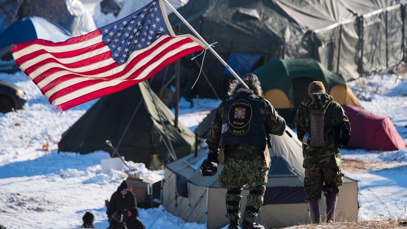 US navy veteran Rob McHaney holds an American flag as he leads a group of activists back from a police barricade on a bridge near Oceti Sakowin camp. Photograph: Jim Watson/AFP/Getty Images
