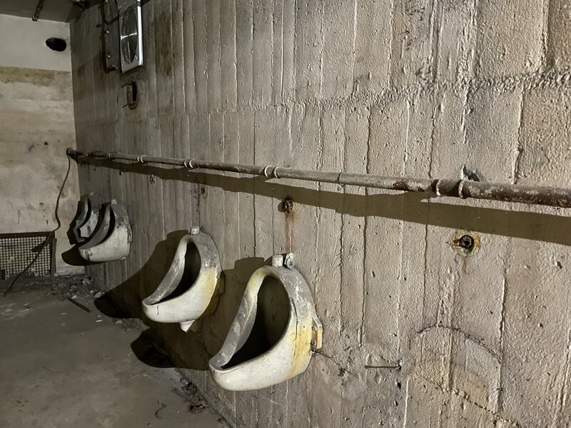 Berlin Story Bunker: Shattered urinals still hang from the wall opposite rotting cubicles.  Photograph: Derek Scally