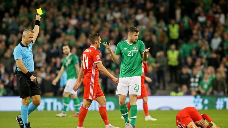 Dutch referee Bjorn Kuipers shows a yellow card to Long. Photo: Paul Faith/Getty Images