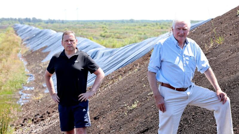 Barry Cowen TD and Cllr Eamon Dooley and former Bord na Móna employee of 46 Years at the remaining peat stockpiles on the Boora Bog near Ferbane. Photograph: Alan Betson / The Irish Times
