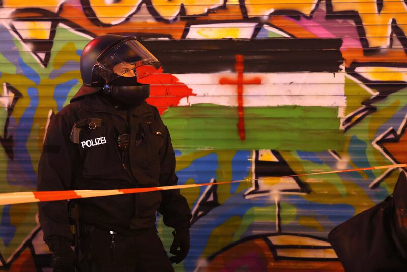 A riot policeman stands next to a graffiti-covered wall that shows a Palestinian flag during a gathering of pro-Palestinian demonstrators in the Neukoelln district of Berlin, where there is a large Arab population. Photograph: Sean Gallup/Getty Images