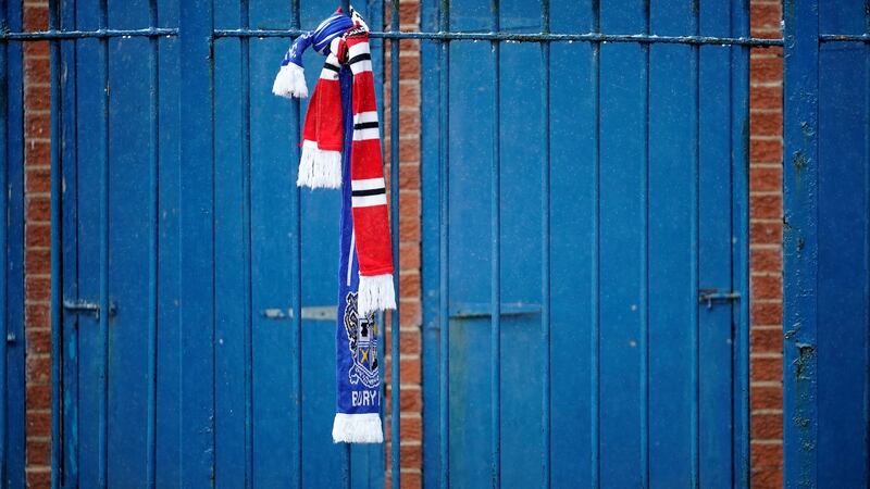 Football scarves adorn the fence of Gigg Lane. Photo: Christopher Furlong/Getty Images