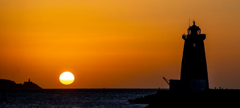 The sun rises over the Poolbeg Lighthouse on the Great South Wall, Dublin. Photograph: Tom Honan