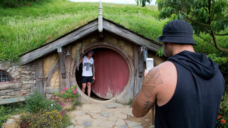 Tourists take photos during a tour of the Hobbit movie set near Matamata, New Zealand. The Lord of the Rings and Hobbit films  have transformed the country into a world leader in ‘film tourism’. Photograph: Mark Baker/AP/File
