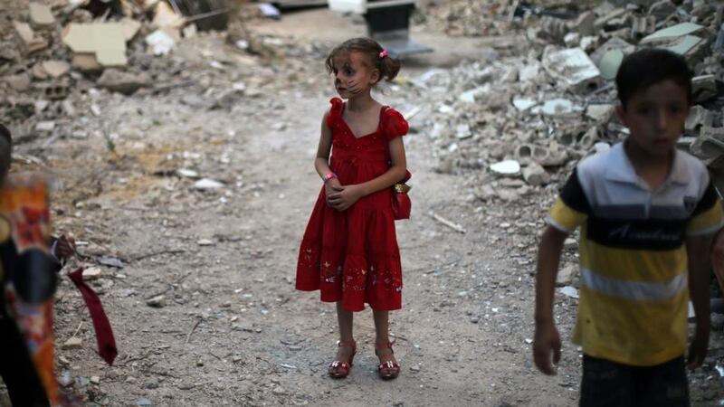 Children stand amid damaged buildings during an activity organised by a charity group in Jobar, a rebel-held district on the eastern outskirts of the capital Damascus, ahead of Eid al-Fitr holiday in Syria. Photograph: Amer Almohibany/AFP/Getty Images